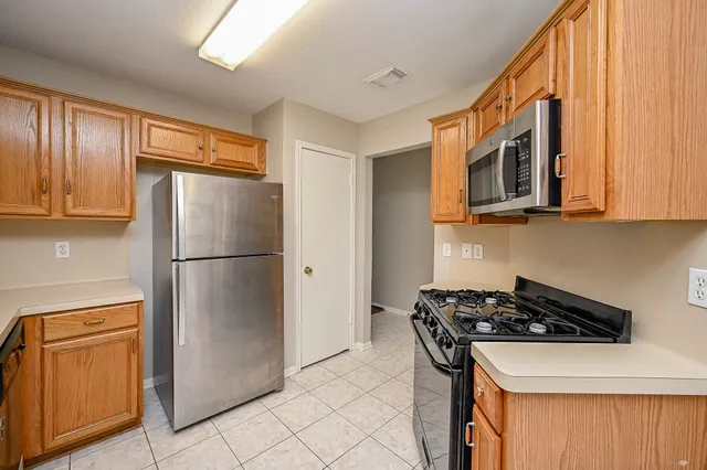 a kitchen with stainless steel appliances granite countertop a refrigerator and a stove top oven