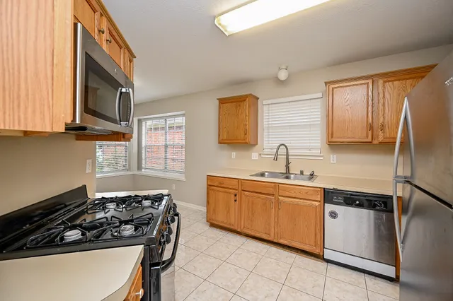 a kitchen with stainless steel appliances granite countertop a sink stove and refrigerator