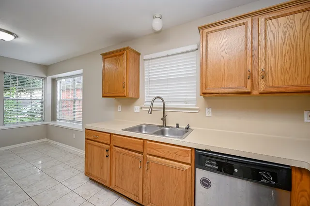 a kitchen with stainless steel appliances granite countertop a sink and a white cabinets