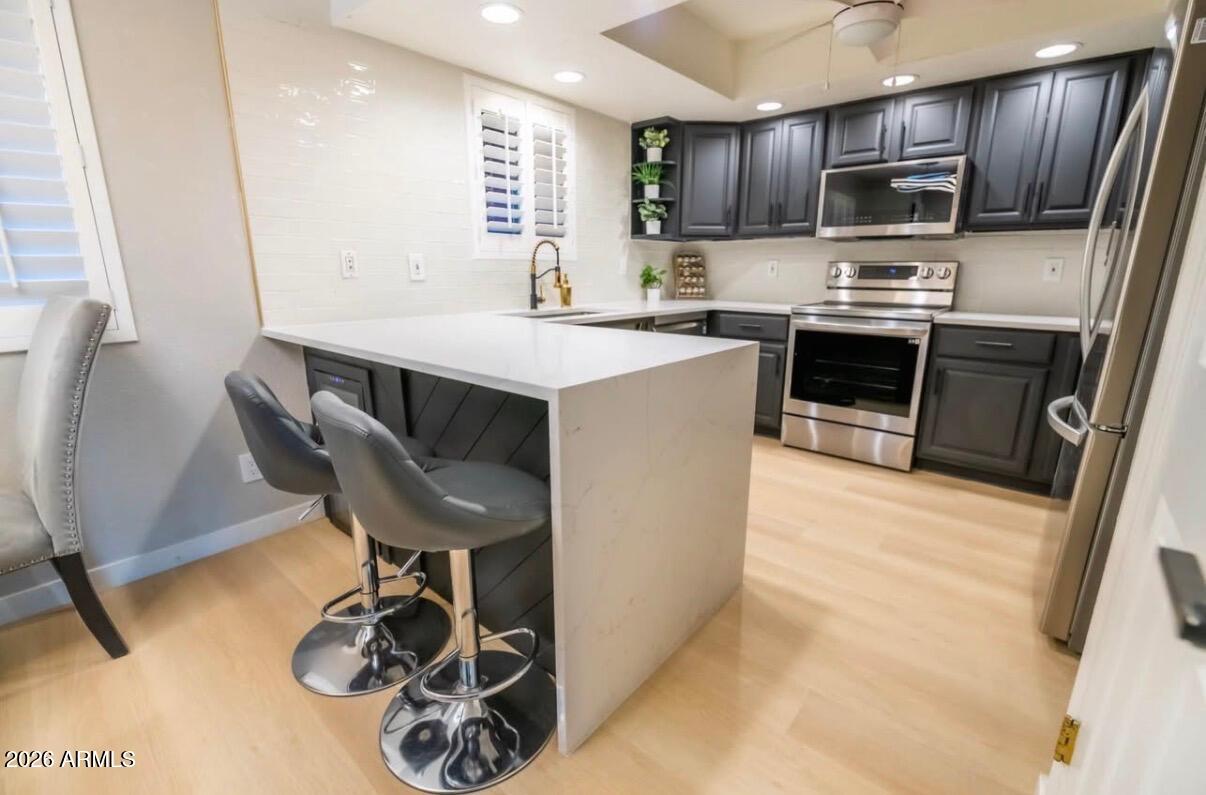 4303 East Cactus Road, Unit 128 Phoenix, AZ 85032 - Photo 24 of 39 a kitchen with kitchen island a appliances dining table and chairs