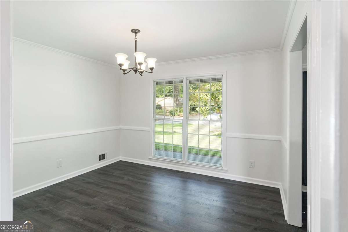 148 Bunker Drive Athens, GA 30607 - Photo 8 of 38 an empty room with wooden floor a chandelier and windows