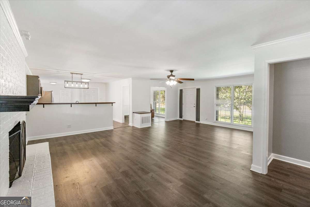 148 Bunker Drive Athens, GA 30607 - Photo 9 of 38 an empty room with wooden floor and a kitchen