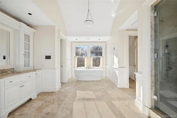 a bathroom with a granite countertop sink a large mirror and a bathtub