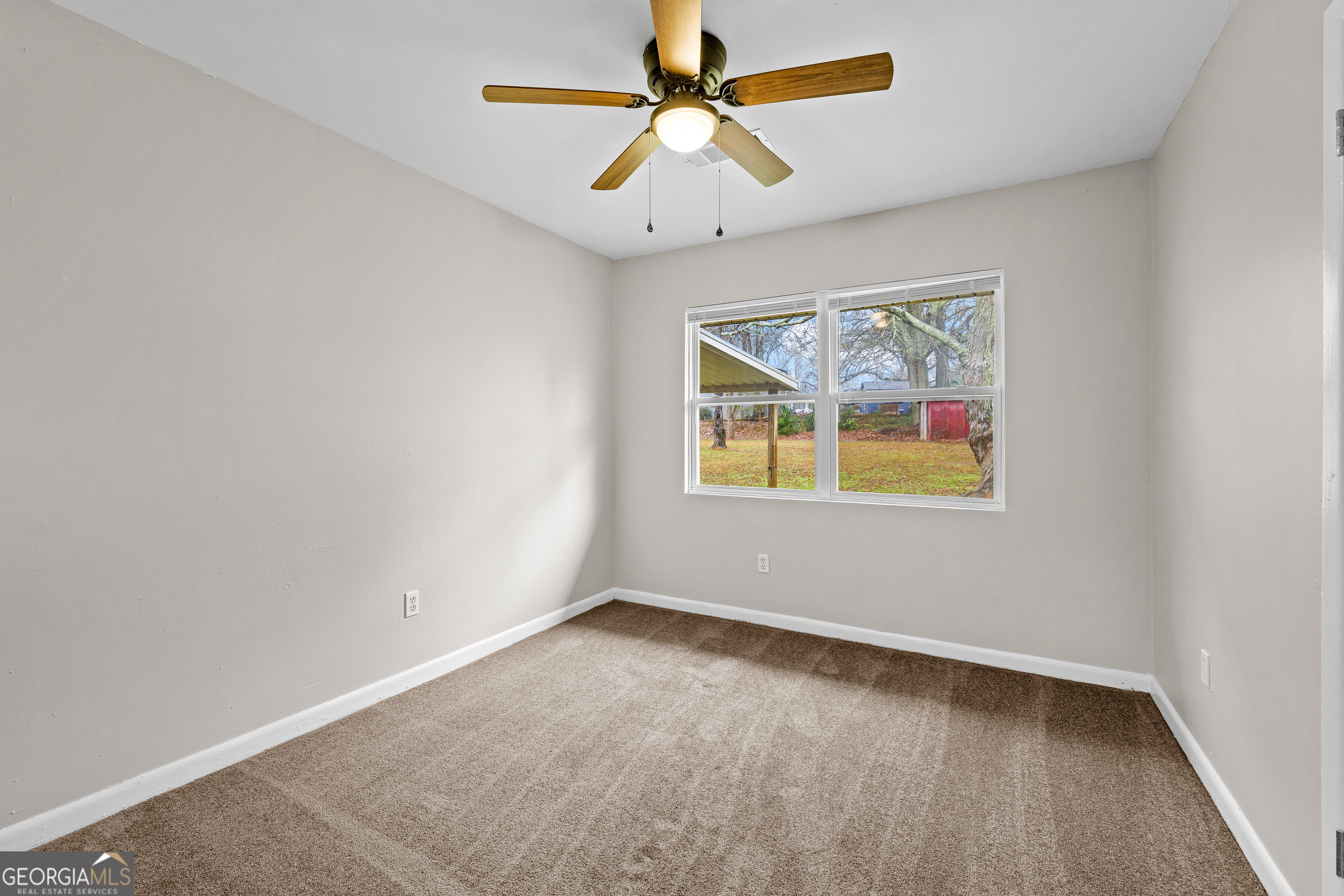 257 Fayetteville Road Fairburn, GA 30213 - Photo 12 of 31 an empty room with chandelier fan and windows
