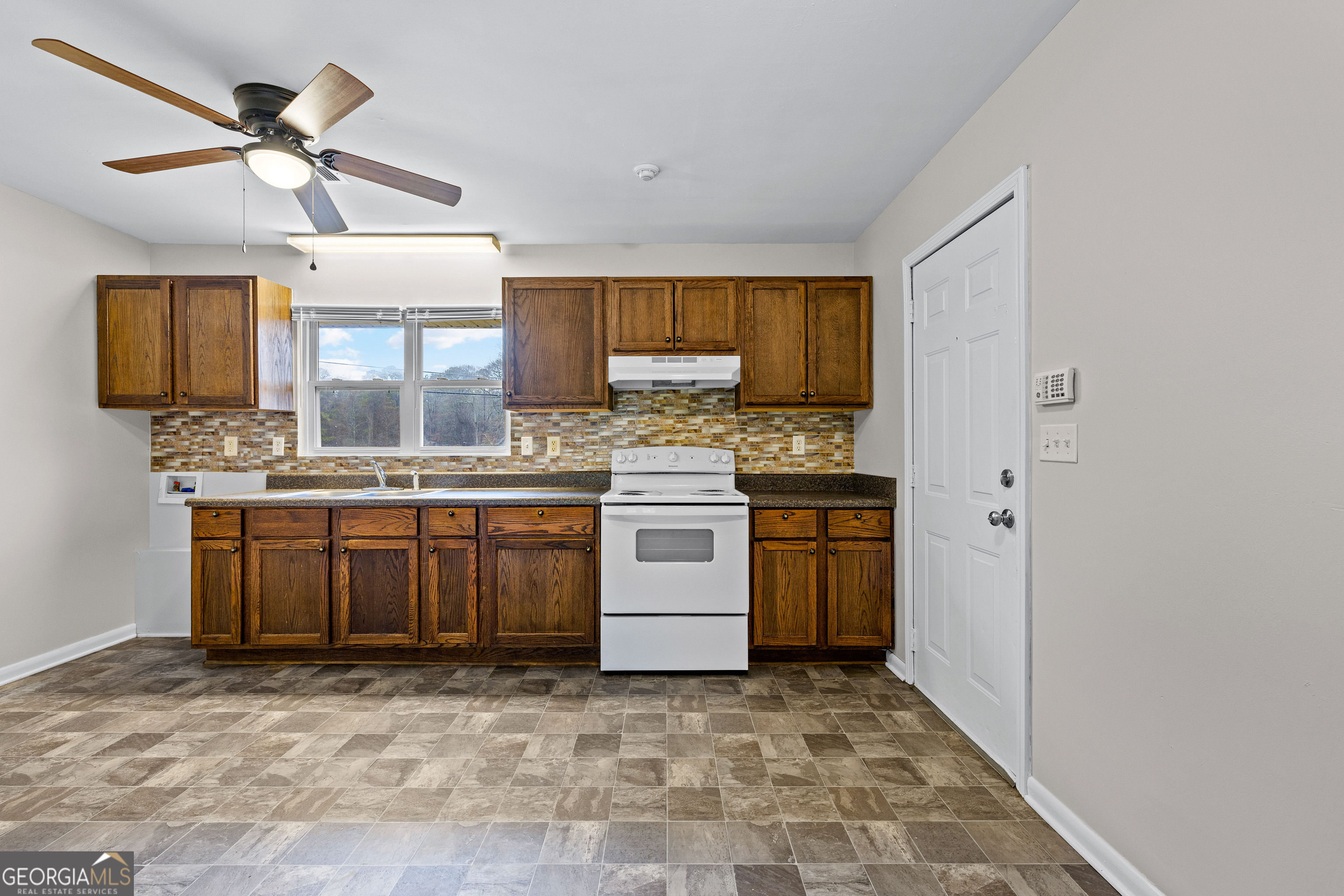 257 Fayetteville Road Fairburn, GA 30213 - Photo 8 of 31 a kitchen with a stove a sink and a refrigerator