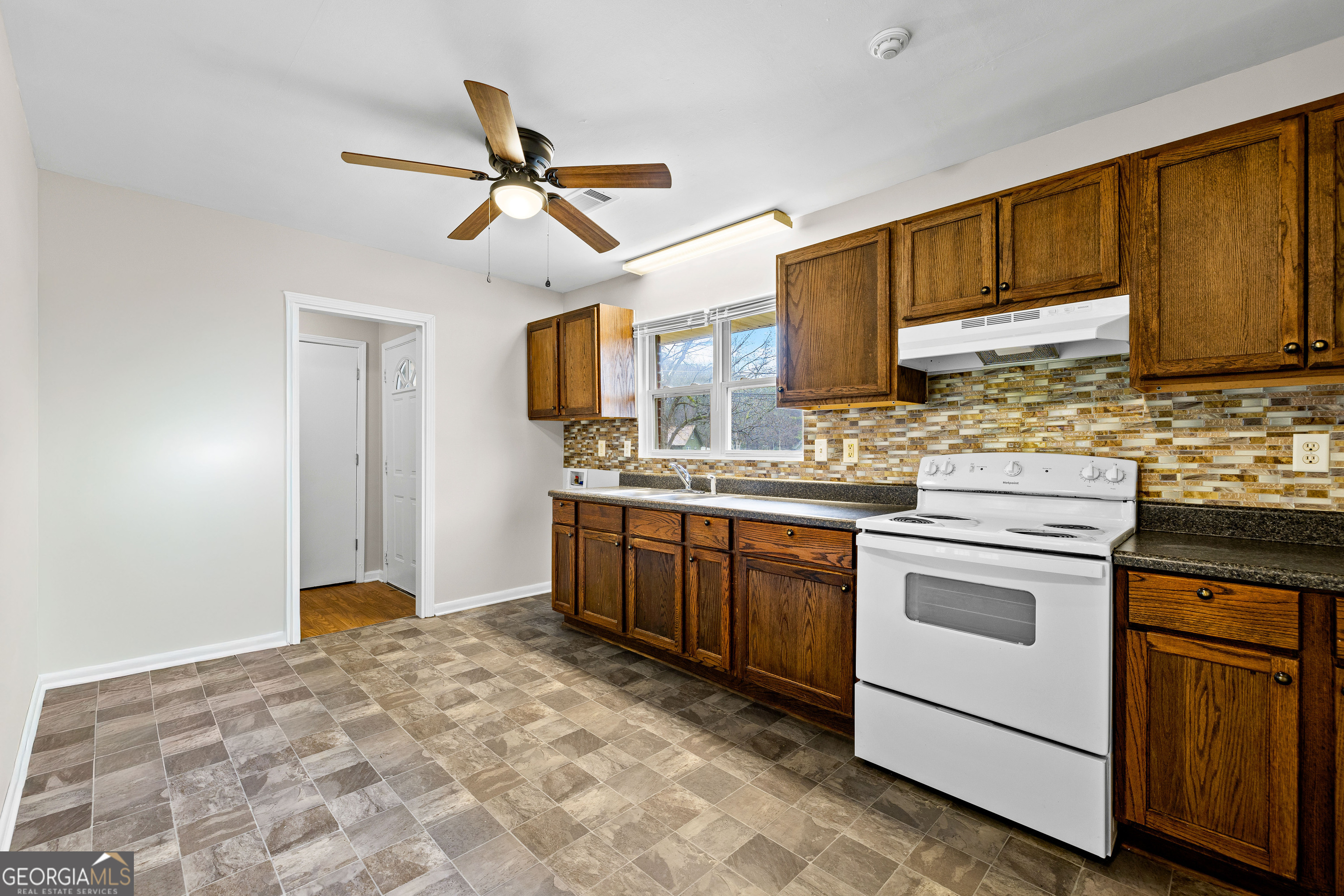 257 Fayetteville Road Fairburn, GA 30213 - Photo 9 of 31 a kitchen with a stove cabinets and a refrigerator