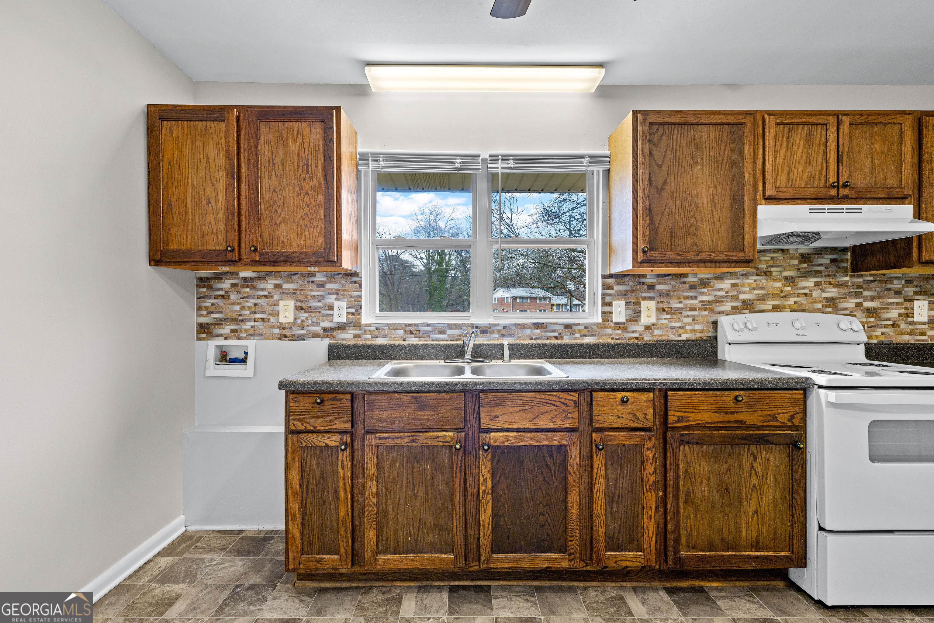257 Fayetteville Road Fairburn, GA 30213 - Photo 10 of 31 a kitchen with kitchen island granite countertop a sink window and cabinets
