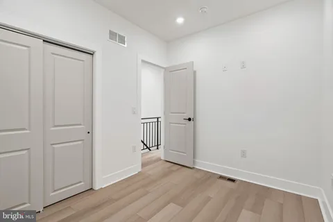 a view of a hallway with stairs and wooden floor