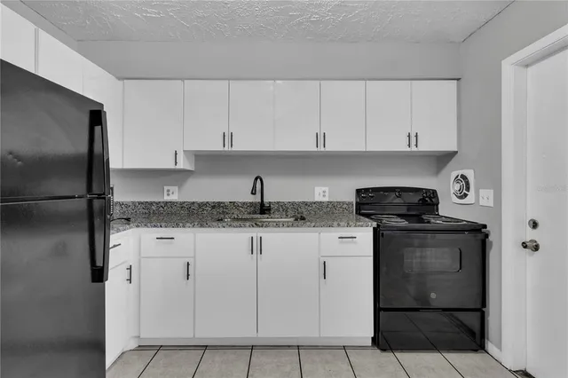 a kitchen with granite countertop a sink stove and refrigerator