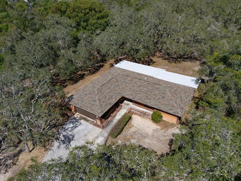 an aerial view of house with yard and trees in the background