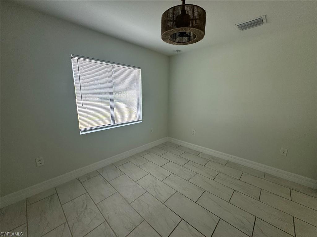 7066 Babcock Road Fort Myers, FL 33967 - Photo 12 of 15 an empty room with a chandelier fan