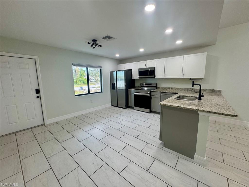 7066 Babcock Road Fort Myers, FL 33967 - Photo 6 of 15 a kitchen with stainless steel appliances granite countertop a sink stove and refrigerator