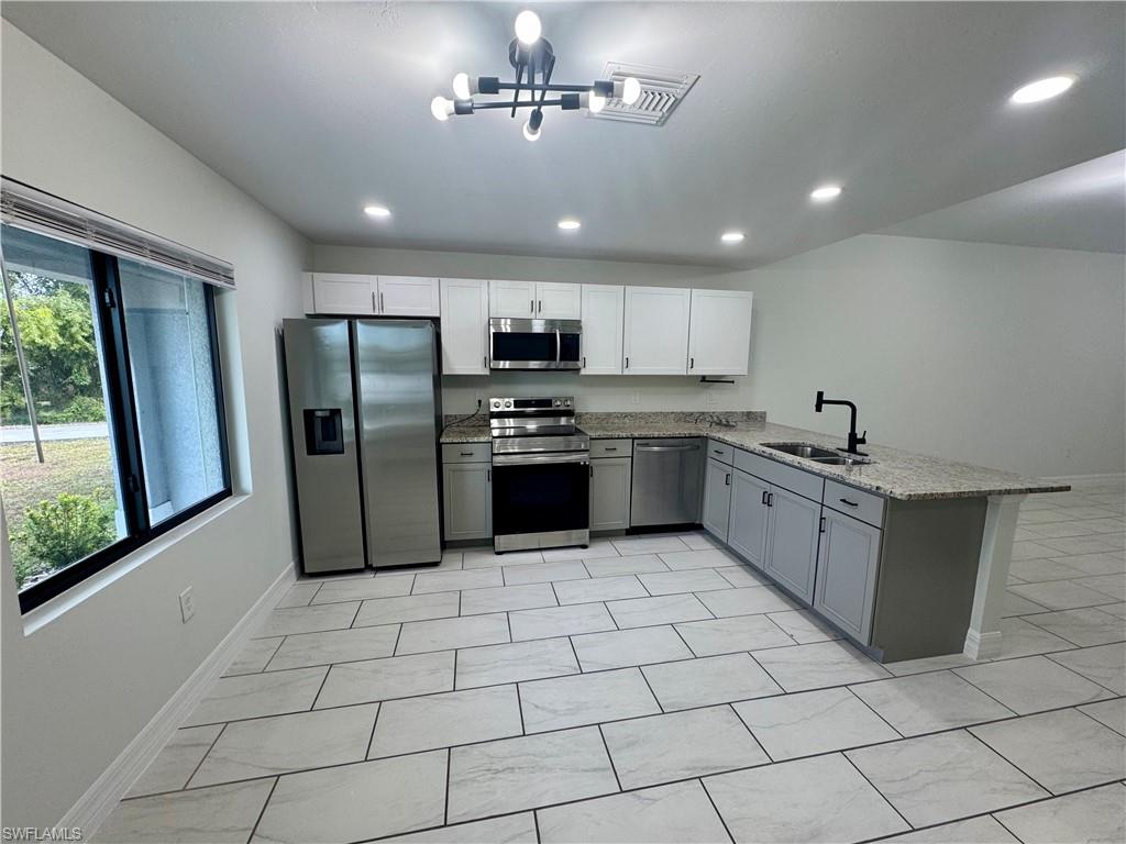 7066 Babcock Road Fort Myers, FL 33967 - Photo 7 of 15 a kitchen with stainless steel appliances granite countertop a refrigerator a sink a stove a washer dryer and a cabinets