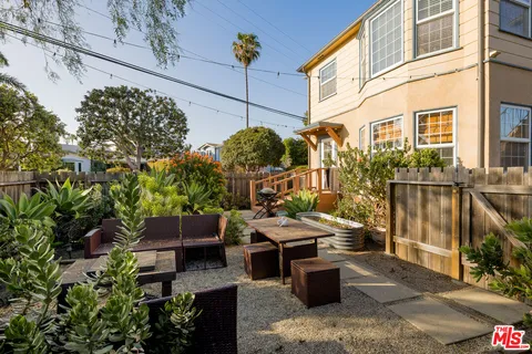 a view of a patio with table and chairs potted plants