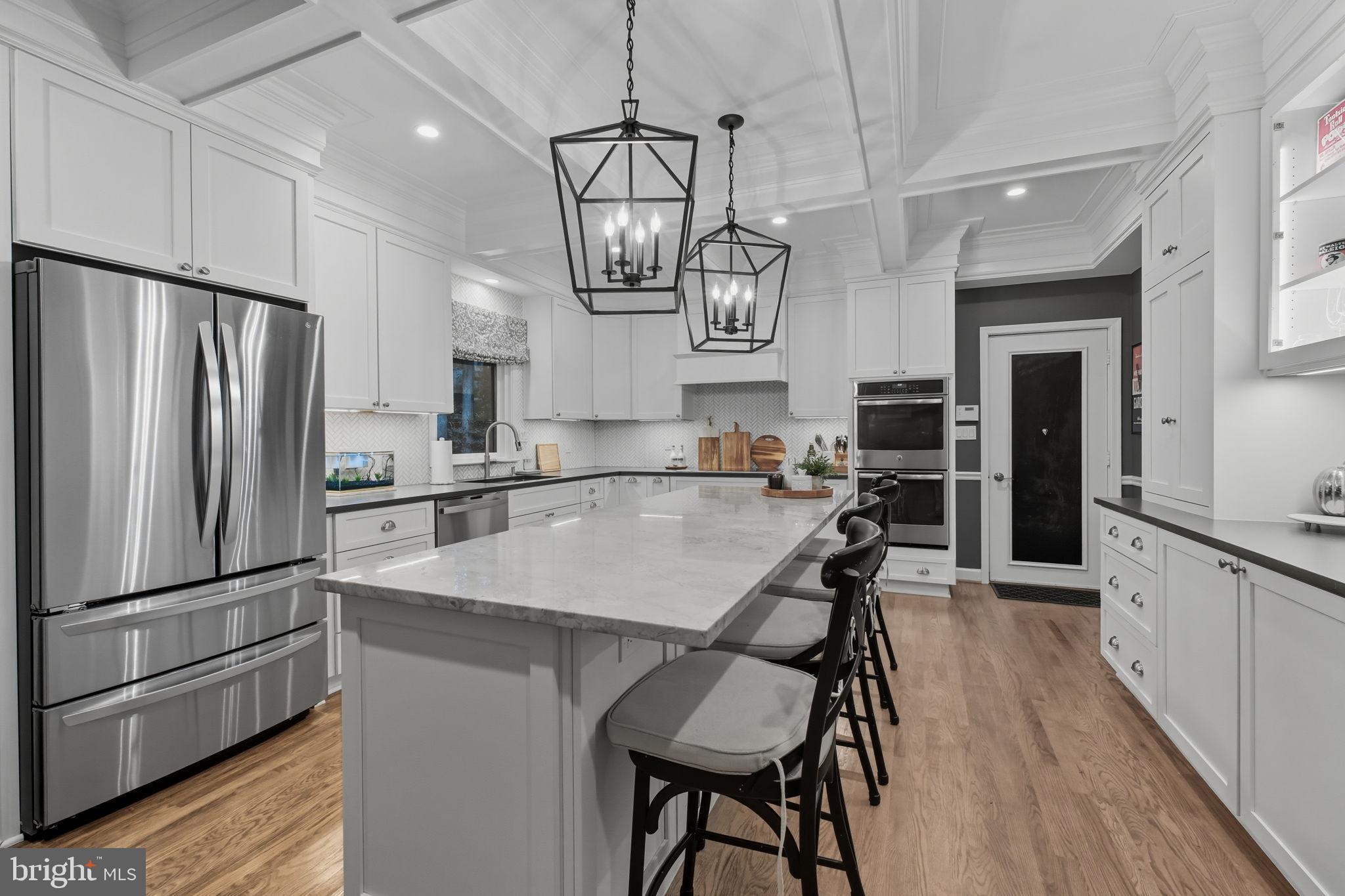 9217 Jeffery Road Great Falls, VA 22066 - Photo 17 of 80 a kitchen with stainless steel appliances a table chairs refrigerator and microwave