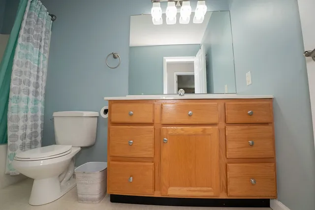 a bathroom with a toilet and a mirror