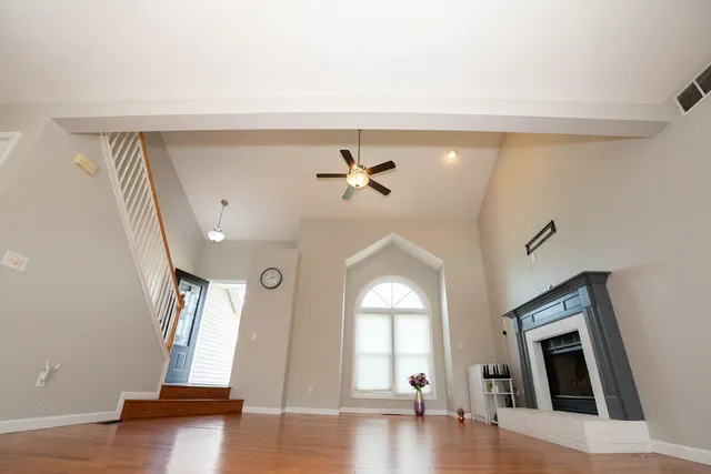 a view of a livingroom with wooden floor and a ceiling fan