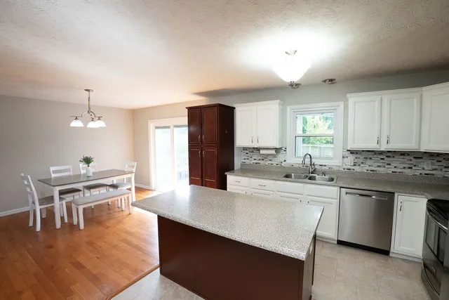 a kitchen with stainless steel appliances granite countertop a sink a stove and refrigerator