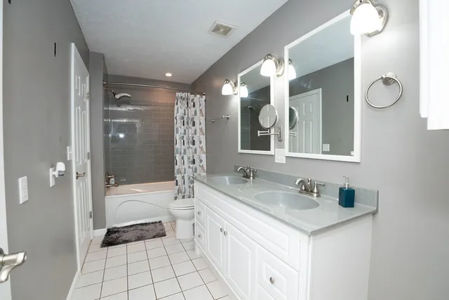 a bathroom with a sink double vanity granite tub and shower