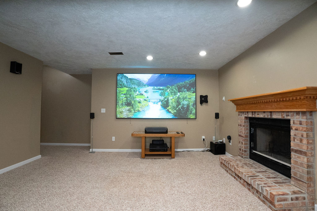 1708 Royal Pointe Drive Bloomington, IL 61704 - Photo 36 of 48 a living room with furniture a flat screen tv and a fireplace