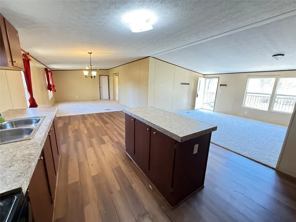 a living room with wooden floors and a sink