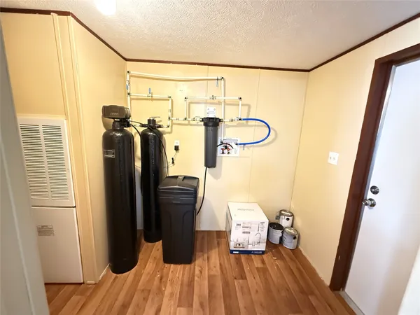 a walk in closet with wooden floor
