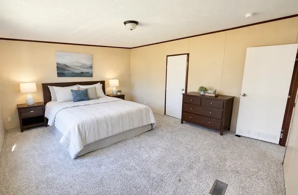 a bedroom with a bed dresser and a large window