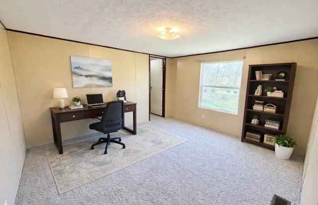 a view of a workspace with furniture and a window