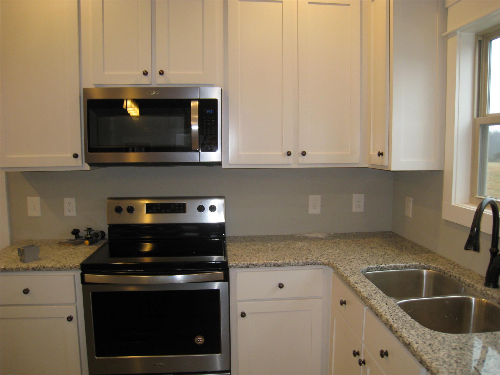 330 East Biggs Road Portland, TN 37148 - Photo 9 of 9 a kitchen with granite countertop white cabinets and a stove top oven
