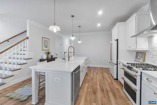a kitchen with granite countertop a sink a counter space appliances and cabinets
