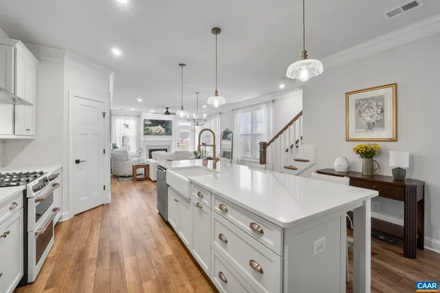 a large kitchen with kitchen island a stove a sink a center island and windows
