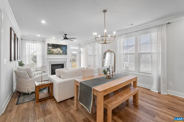 a living room with furniture a fireplace and a chandelier