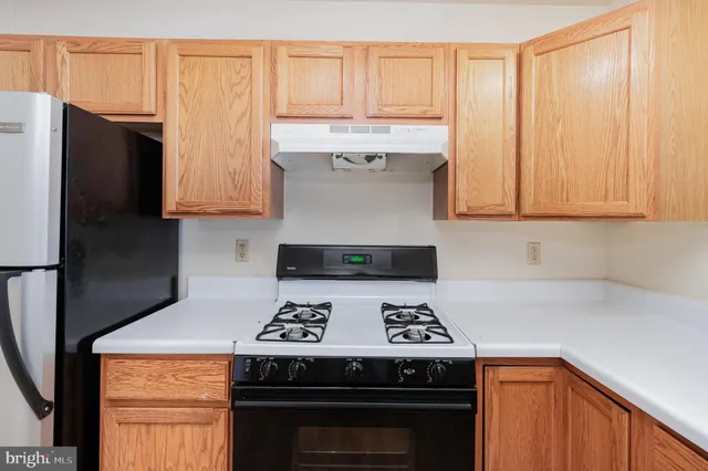 a kitchen with stainless steel appliances granite countertop a stove a refrigerator and a stove