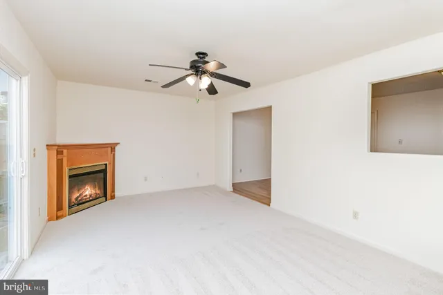 a view of an empty room with a fireplace and a window
