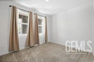 a living room with furniture a flat screen tv and a large window