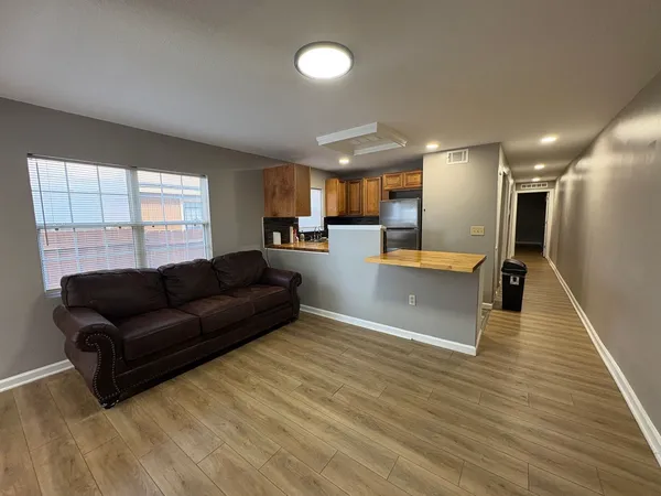 a living room with furniture and a wooden floor