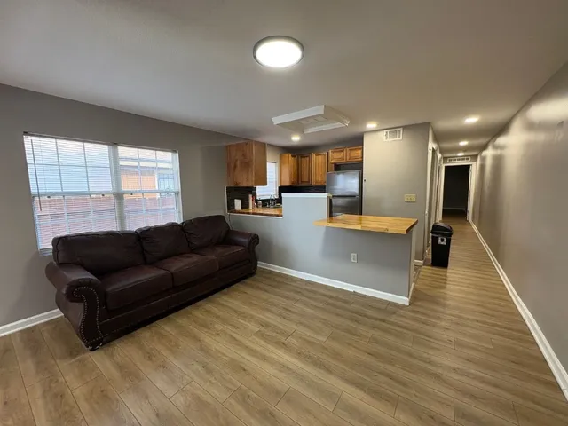 a living room with furniture and a wooden floor