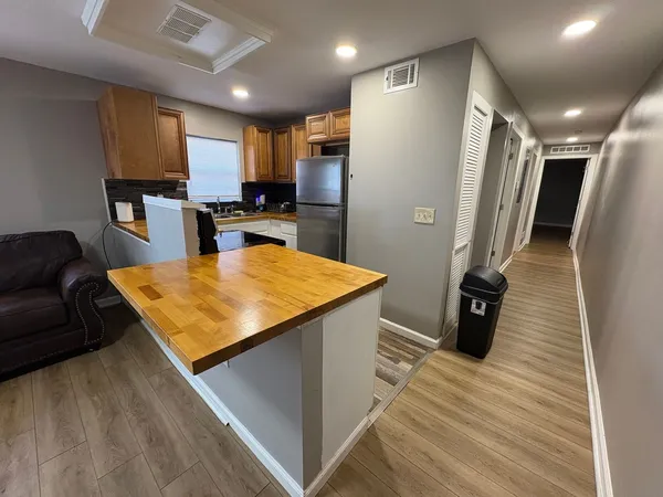 a kitchen with stainless steel appliances a refrigerator a stove a microwave oven a sink with island and chairs