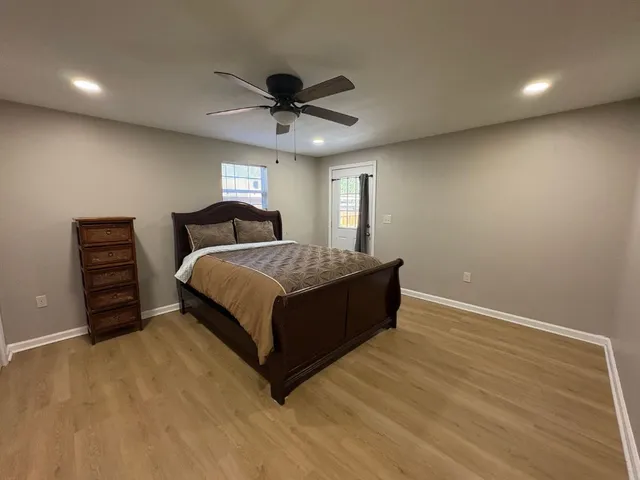 a spacious bedroom with a bed and a ceiling fan