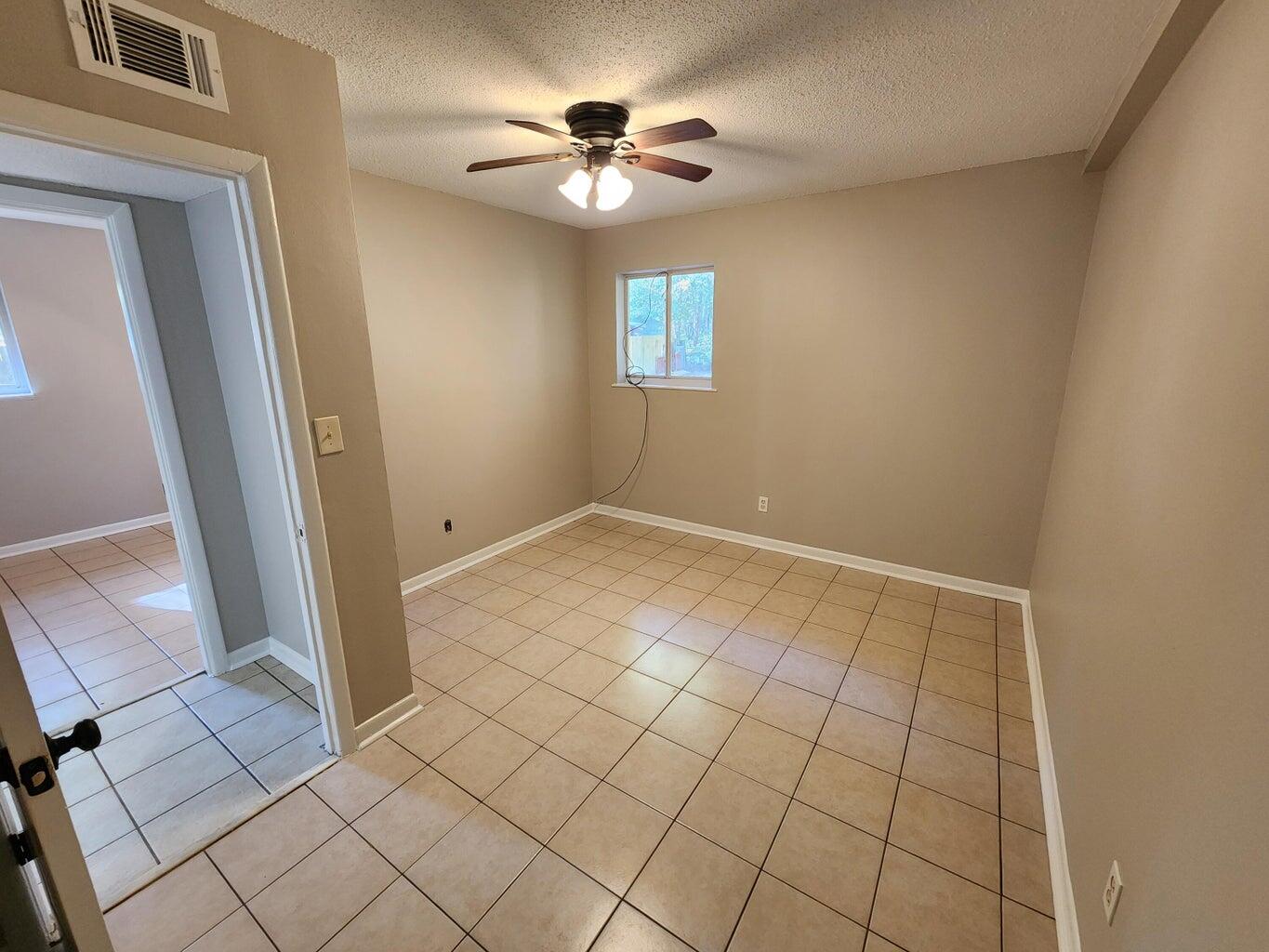128 Smith Street Crestview, FL 32539 - Photo 12 of 13 wooden floor in an empty room with a window