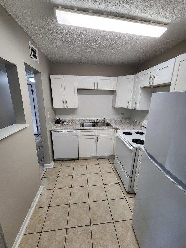 128 Smith Street Crestview, FL 32539 - Photo 13 of 13 a kitchen with a sink a stove a refrigerator and cabinets