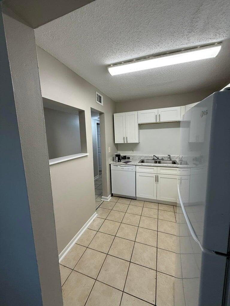 128 Smith Street Crestview, FL 32539 - Photo 5 of 13 a kitchen with a stove a refrigerator and white cabinets