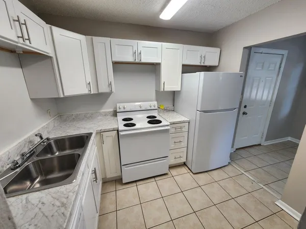 a kitchen with a refrigerator sink and cabinets