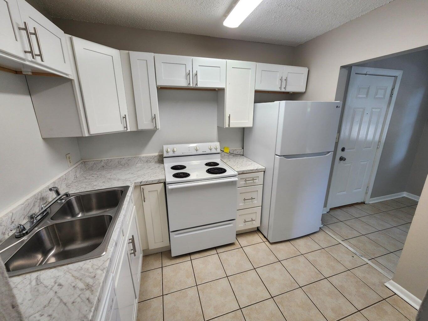128 Smith Street Crestview, FL 32539 - Photo 6 of 13 a kitchen with a refrigerator sink and cabinets