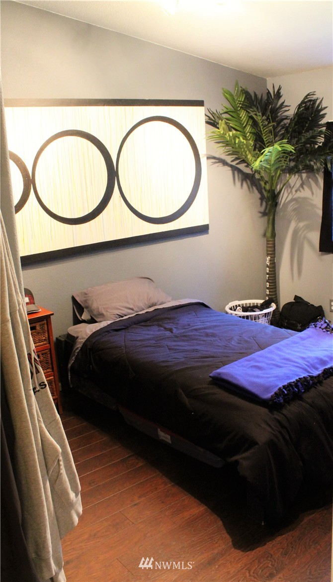 6516 Wahl Road Freeland, WA 98249 - Photo 22 of 24 a bedroom with a bed and a potted plant