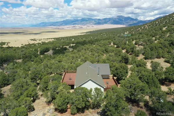 an aerial view of house with yard and mountain view in back