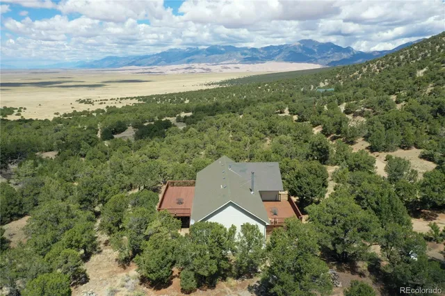 an aerial view of house with yard and mountain view in back
