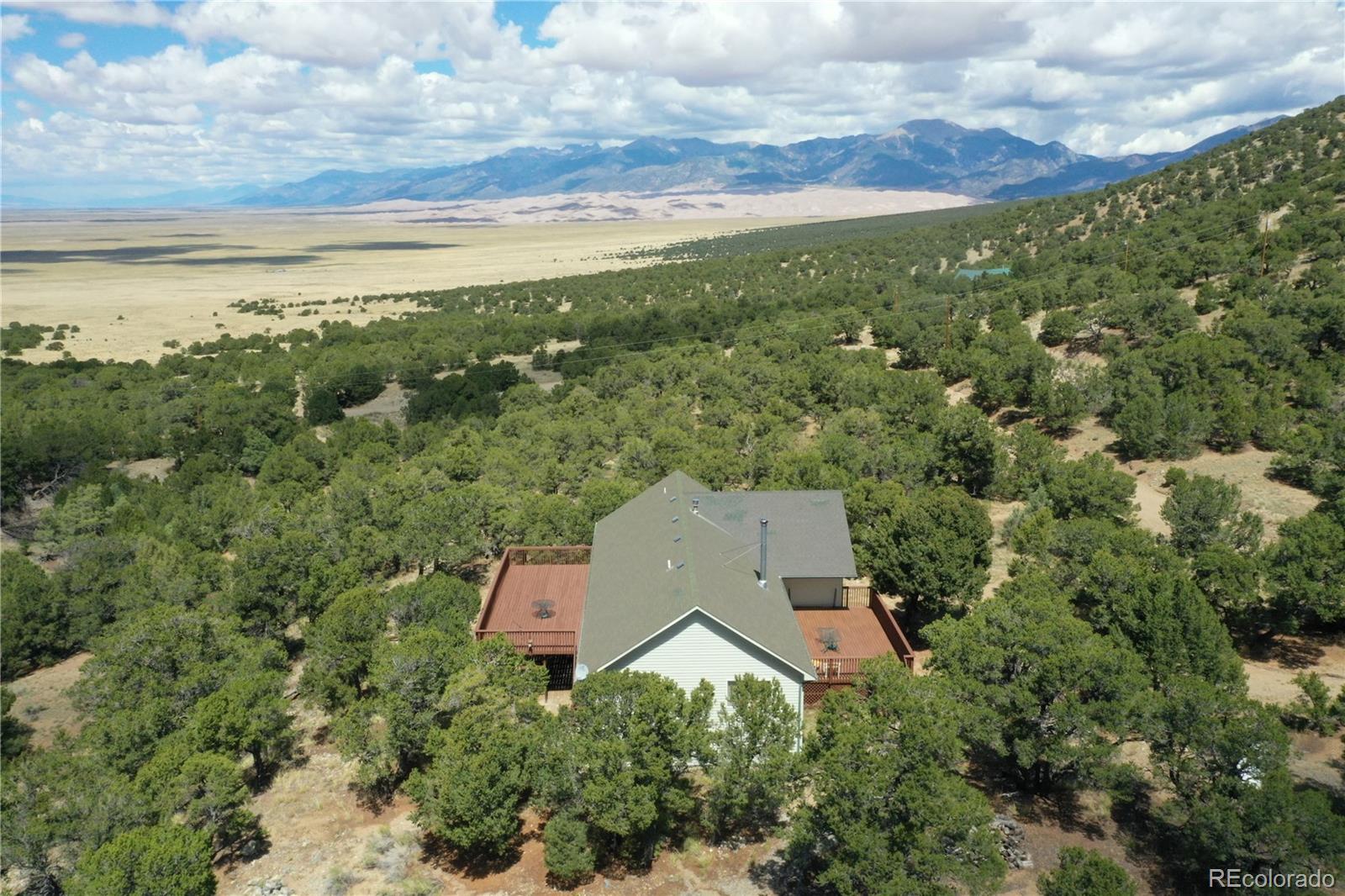 an aerial view of house with yard and mountain view in back