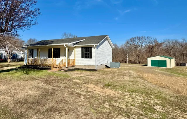 a front view of a house with a yard and trees