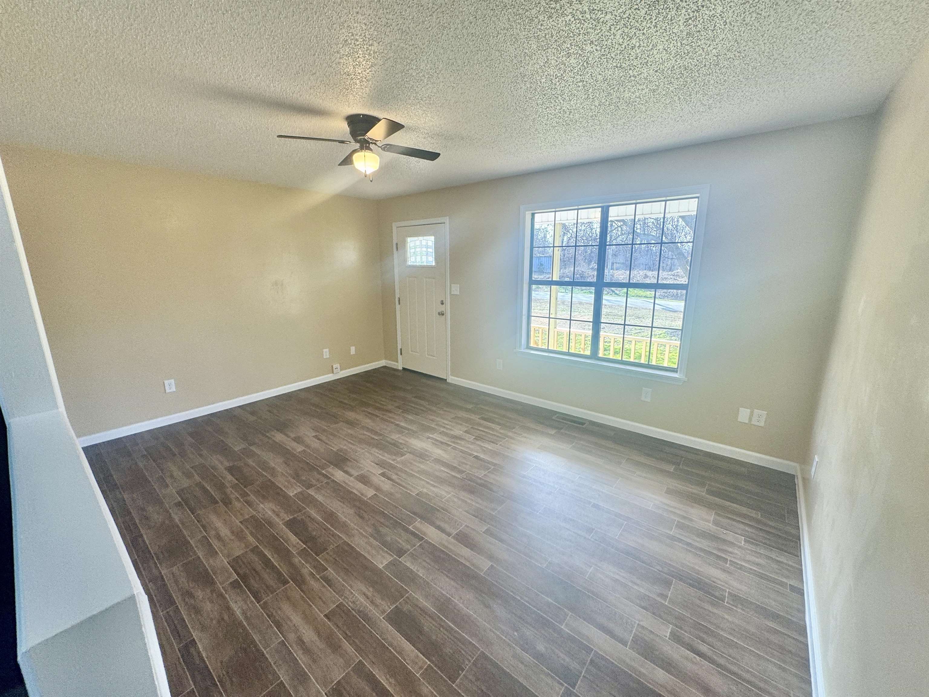 250 Dr Lewis Road Ripley, TN 38063 - Photo 9 of 18 an empty room with wooden floor fan and windows